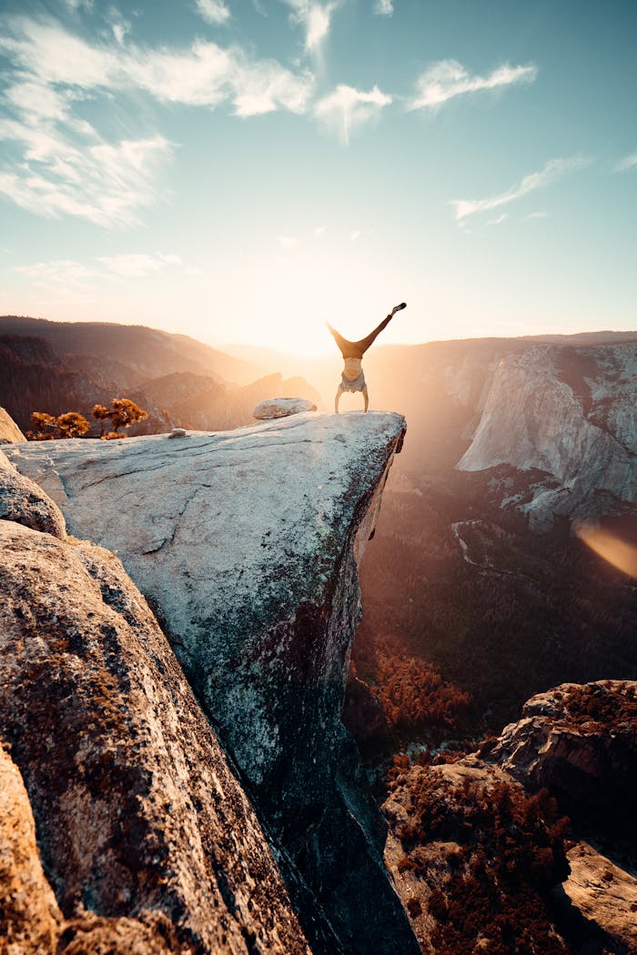 about-us Thrilling handstand on a cliff edge in Yosemite National Park during sunset.